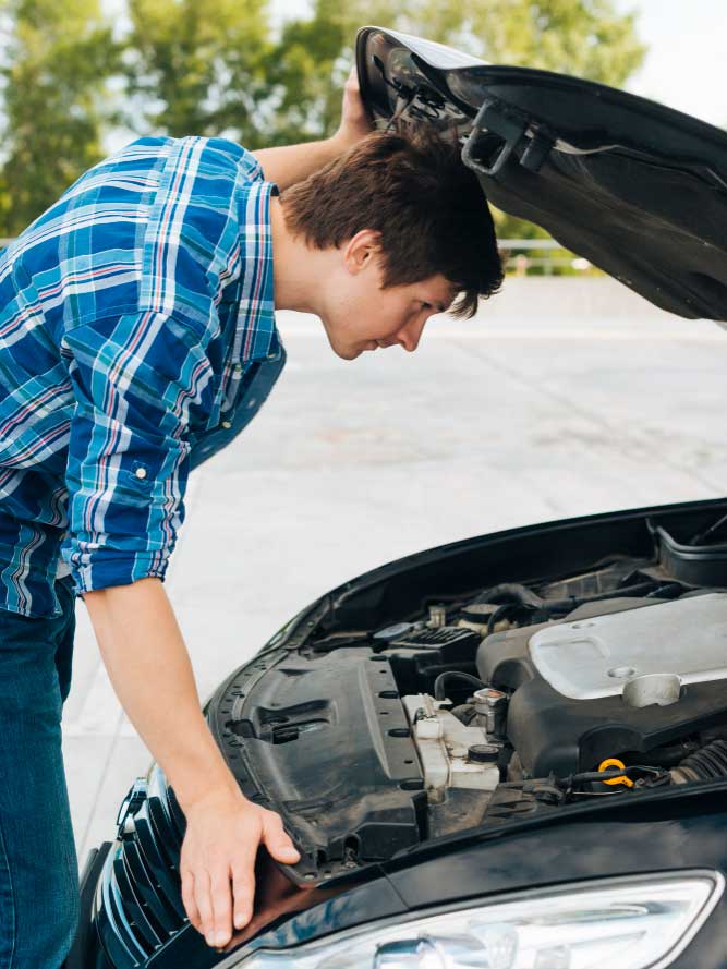 Junger Mann prüft Getriebeschaden bei Schrottauto Ankauf Rendsburg